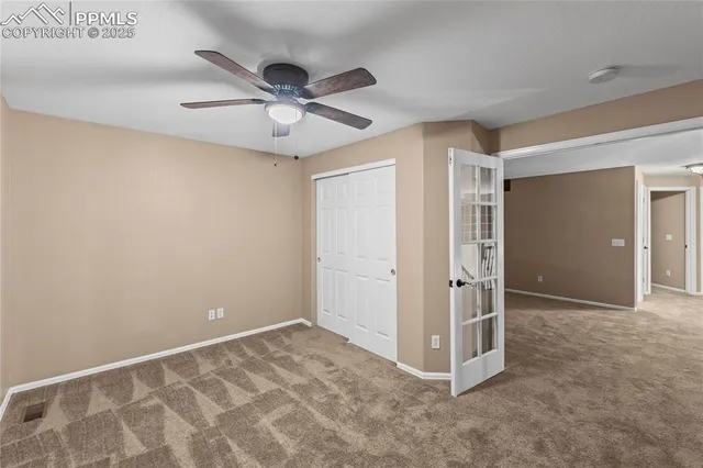 a view of a livingroom with a ceiling fan & entryway