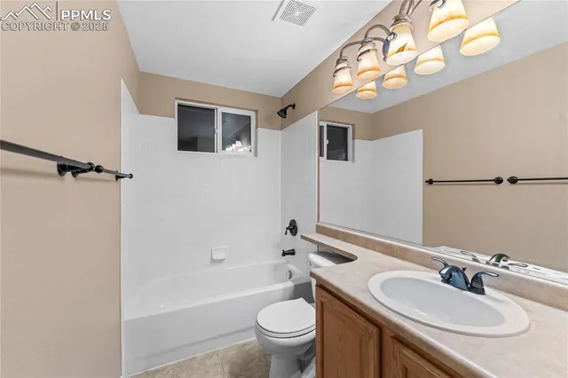 a bathroom with a granite countertop sink toilet a mirror a bathtub and shower