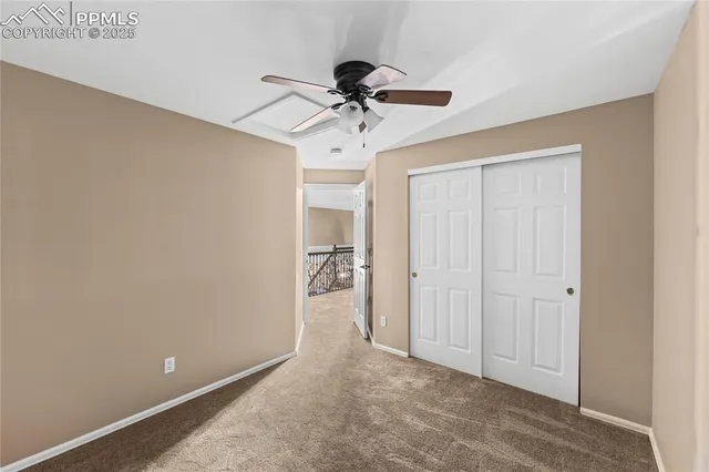 a view of hallway with chandelier fan