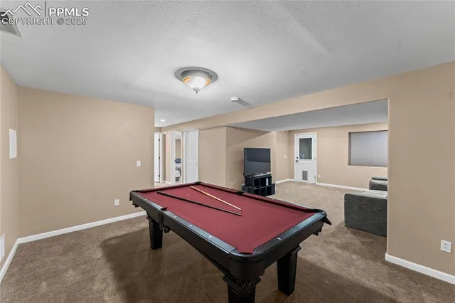 a room with pool table and windows