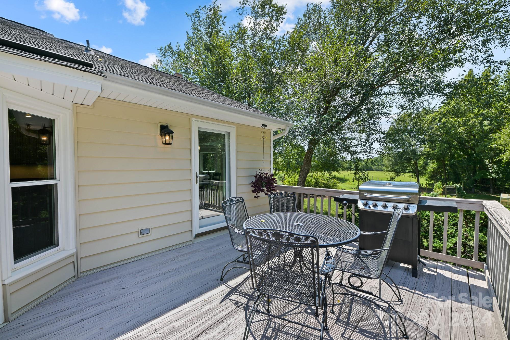 1135 Arabian Farm Road Clover, SC 29710 - Photo 27 of 48 a view of a patio with table and chairs with wooden floor and fence