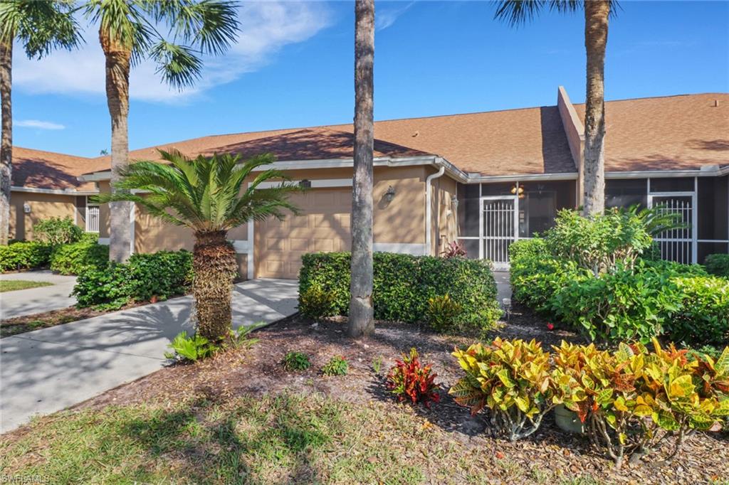 1677 Morning Sun Lane Naples, FL 34119 - Photo 1 of 41 a front view of a house with a yard and potted plants