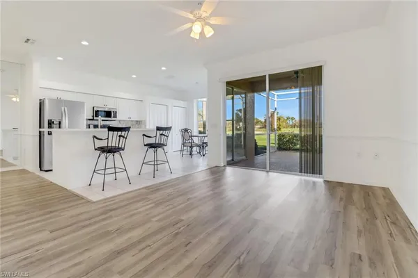 a view of a livingroom with furniture wooden floor and a ceiling fan