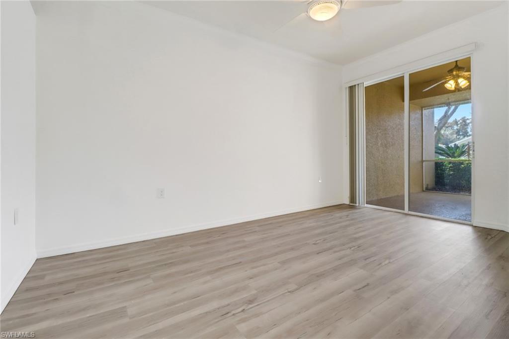 1677 Morning Sun Lane Naples, FL 34119 - Photo 17 of 41 a view of an empty room with wooden floor and a window