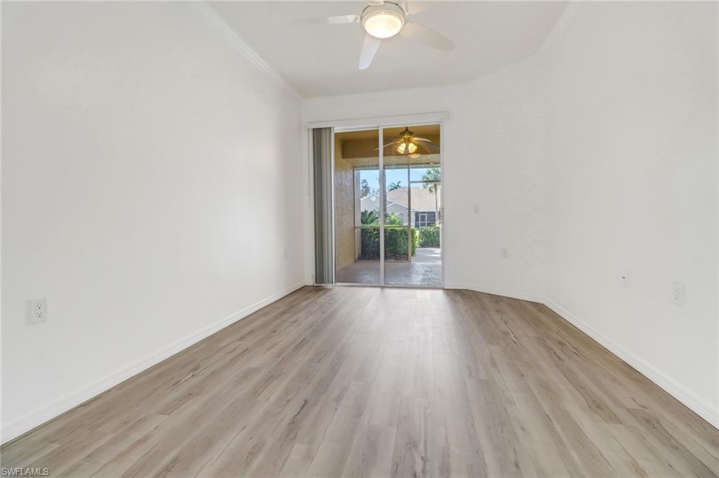 1677 Morning Sun Lane Naples, FL 34119 - Photo 18 of 41 a view of an empty room with wooden floor and a window