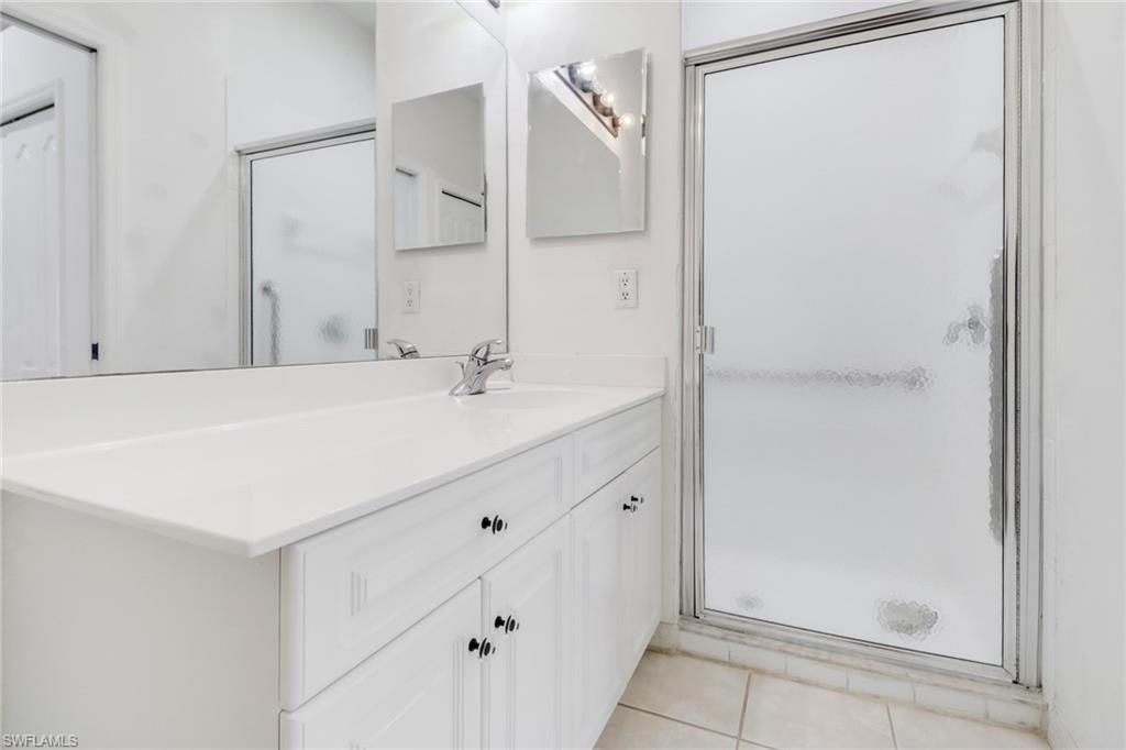 1677 Morning Sun Lane Naples, FL 34119 - Photo 19 of 41 a bathroom with a sink and a mirror