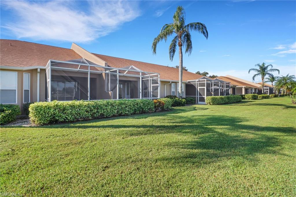 1677 Morning Sun Lane Naples, FL 34119 - Photo 27 of 41 a front view of a house with garden and trees