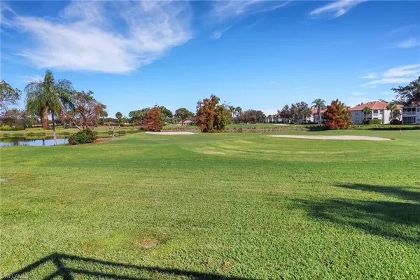 a yard with lots of green space and trees in the background