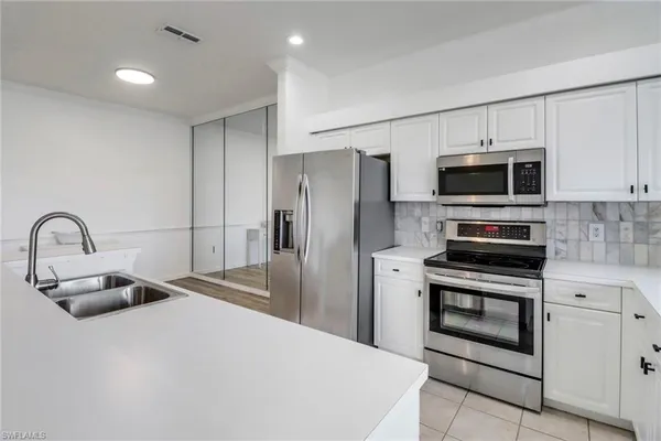 a kitchen with stainless steel appliances a stove a sink and a refrigerator