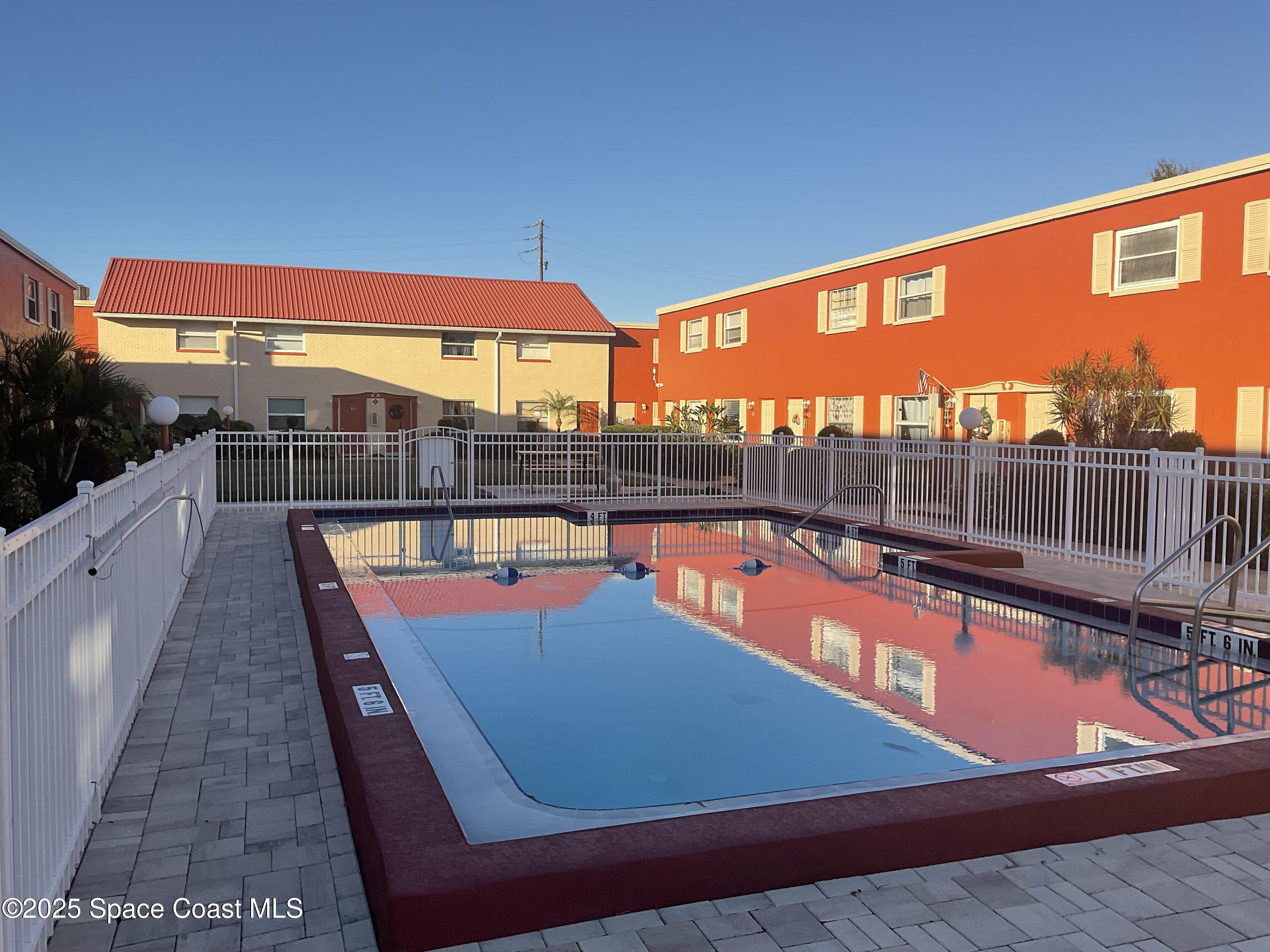 50 Needle Boulevard, Unit 29 Merritt Island, FL 32953 - Photo 11 of 11 a view of a swimming pool with a lounge chair