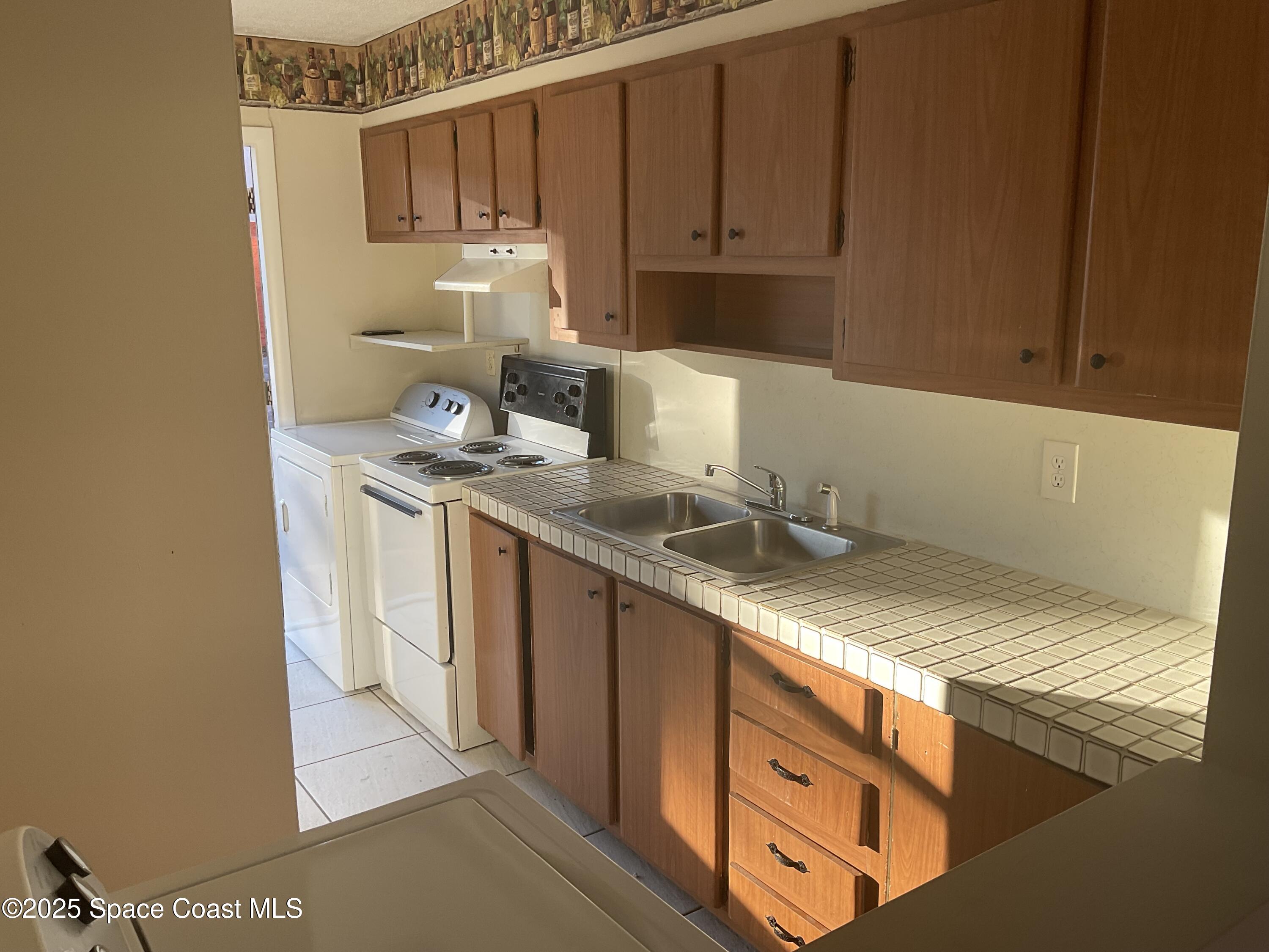 50 Needle Boulevard, Unit 29 Merritt Island, FL 32953 - Photo 2 of 11 a kitchen with stainless steel appliances granite countertop a sink stove and cabinets