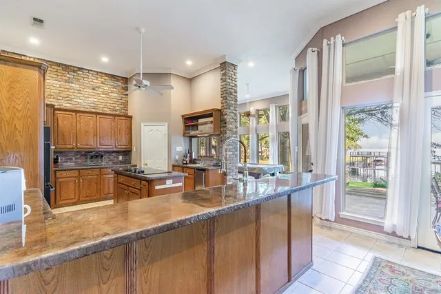 a kitchen with large windows and refrigerator