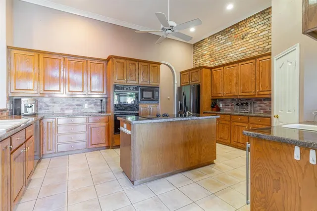 a view of kitchen with stainless steel appliances granite countertop a refrigerator a stove and a sink