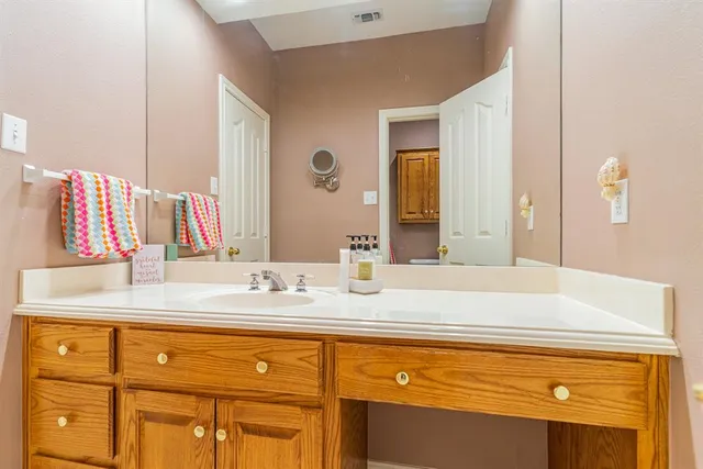 a bathroom with a granite countertop double vanity sink and mirror