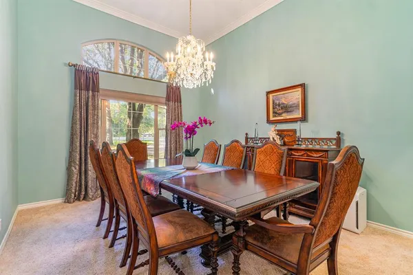 a view of a dining room with furniture and chandelier