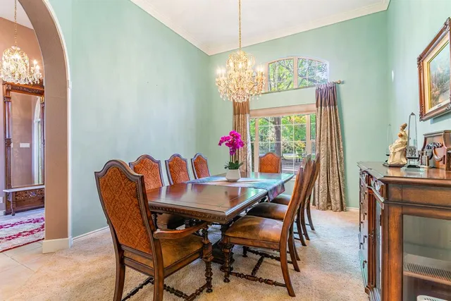 a dining room with furniture a chandelier and window