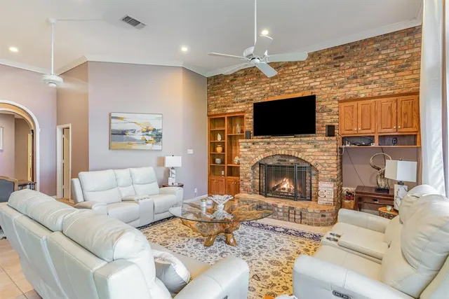 a living room with furniture a fireplace and a flat screen tv