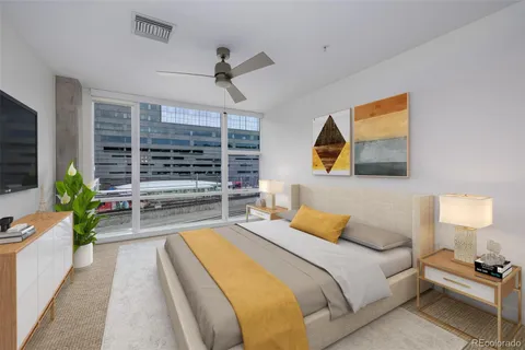 a bedroom with a large bed and a flat tv screen on dresser