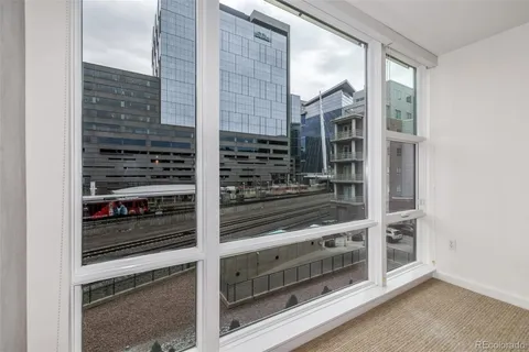 a view of an empty room with wooden floor and windows