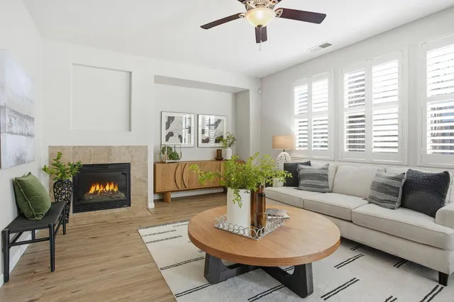 a living room with furniture a fireplace and a large window