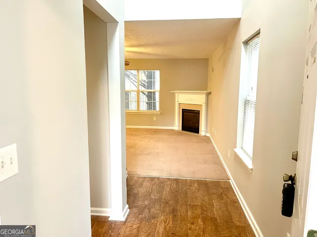 a view of a hallway with wooden floor and a living room