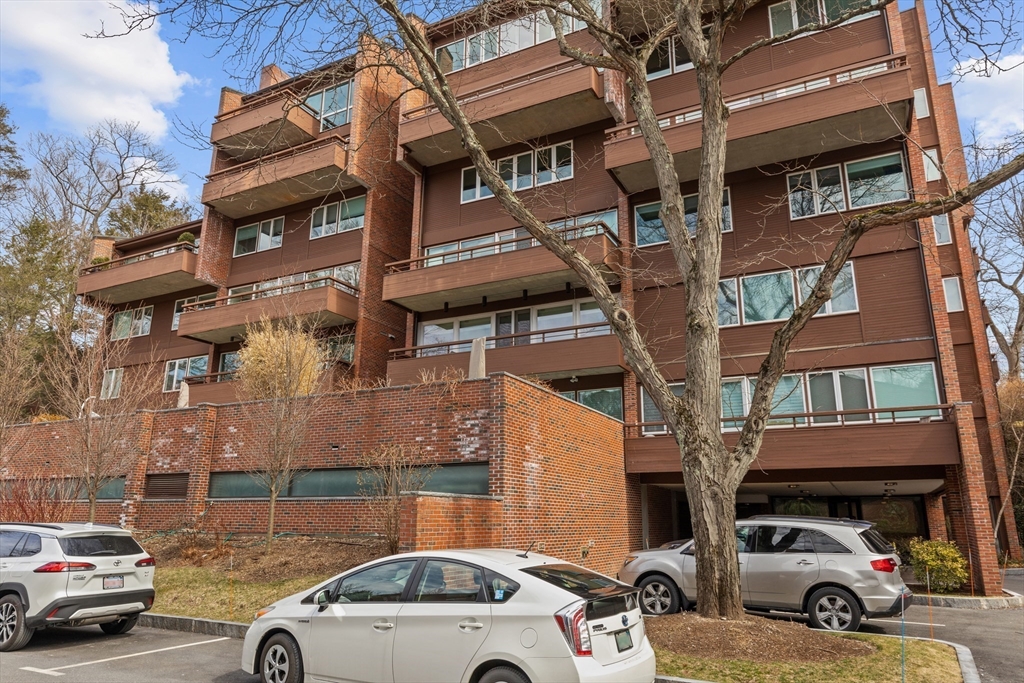 241 Perkins Street, Unit D405 Boston, MA 02130 - Photo 2 of 36 a view of cars parked in front of a building