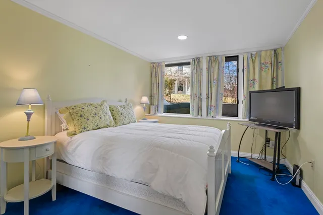 a bedroom with a bed and a flat screen tv on the dresser