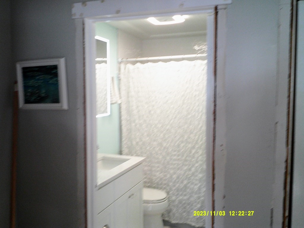 77 Indian Run Road, Unit 77 Bellingham, MA 02019 - Photo 17 of 18 a bathroom with a granite countertop sink toilet and a mirror