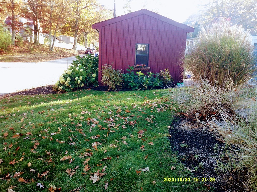 77 Indian Run Road, Unit 77 Bellingham, MA 02019 - Photo 7 of 18 a view of a big yard with plants and a bench