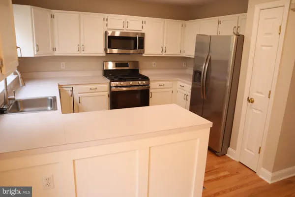 a kitchen with stainless steel appliances a refrigerator sink and stove