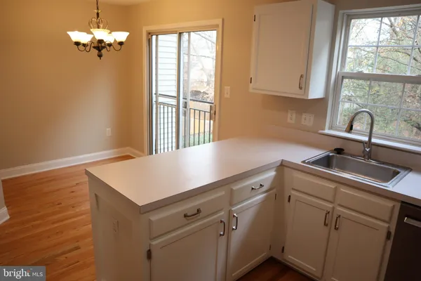 a view of a kitchen with a sink dishwasher and wooden floor