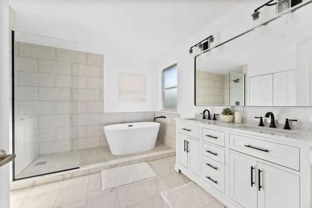 a bathroom with a granite countertop sink mirror and bathtub