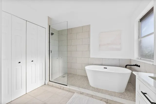 a white bath tub sitting next to a shower