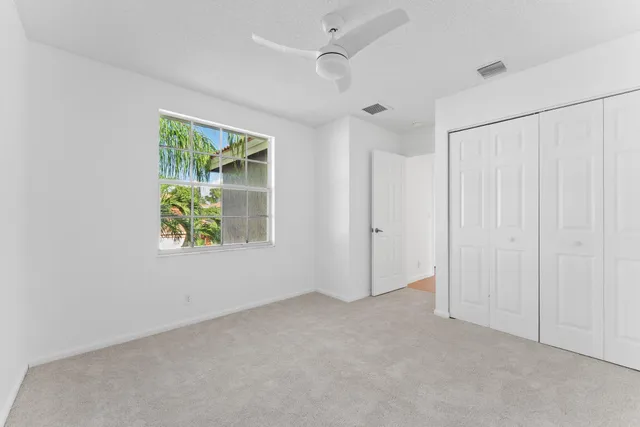 an empty room with windows and closet