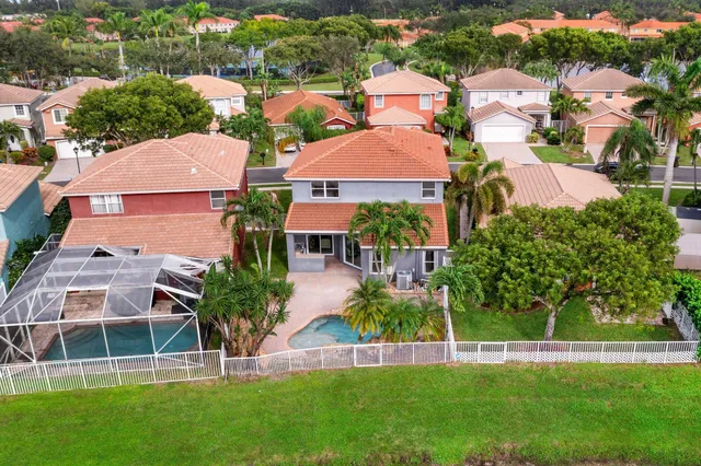 an aerial view of residential houses with outdoor space and trees
