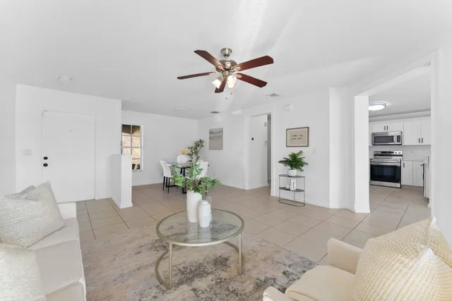 a living room with furniture and a dining table with kitchen view