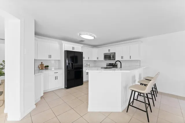 a kitchen with a refrigerator a microwave a stove top oven and cabinets