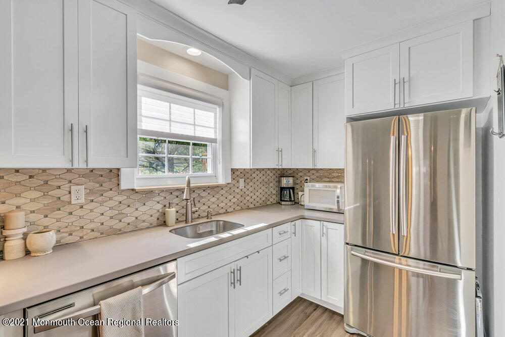 39 Bramble Lane Matawan, NJ 07747 - Photo 11 of 28 a kitchen with stainless steel appliances granite countertop a refrigerator sink and white cabinets