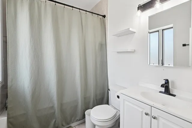 a bathroom with a sink a toilet and shower curtain