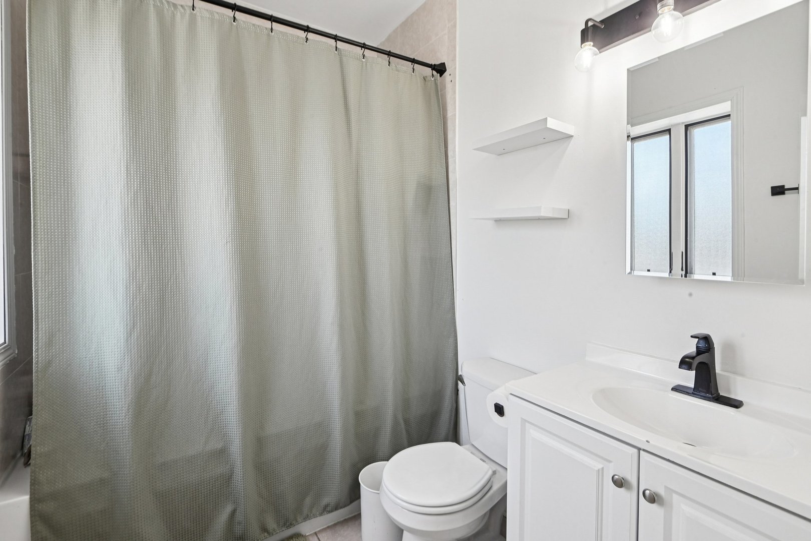 828 West 31st Street, Unit 3N Chicago, IL 60608 - Photo 23 of 29 a bathroom with a sink a toilet and shower curtain