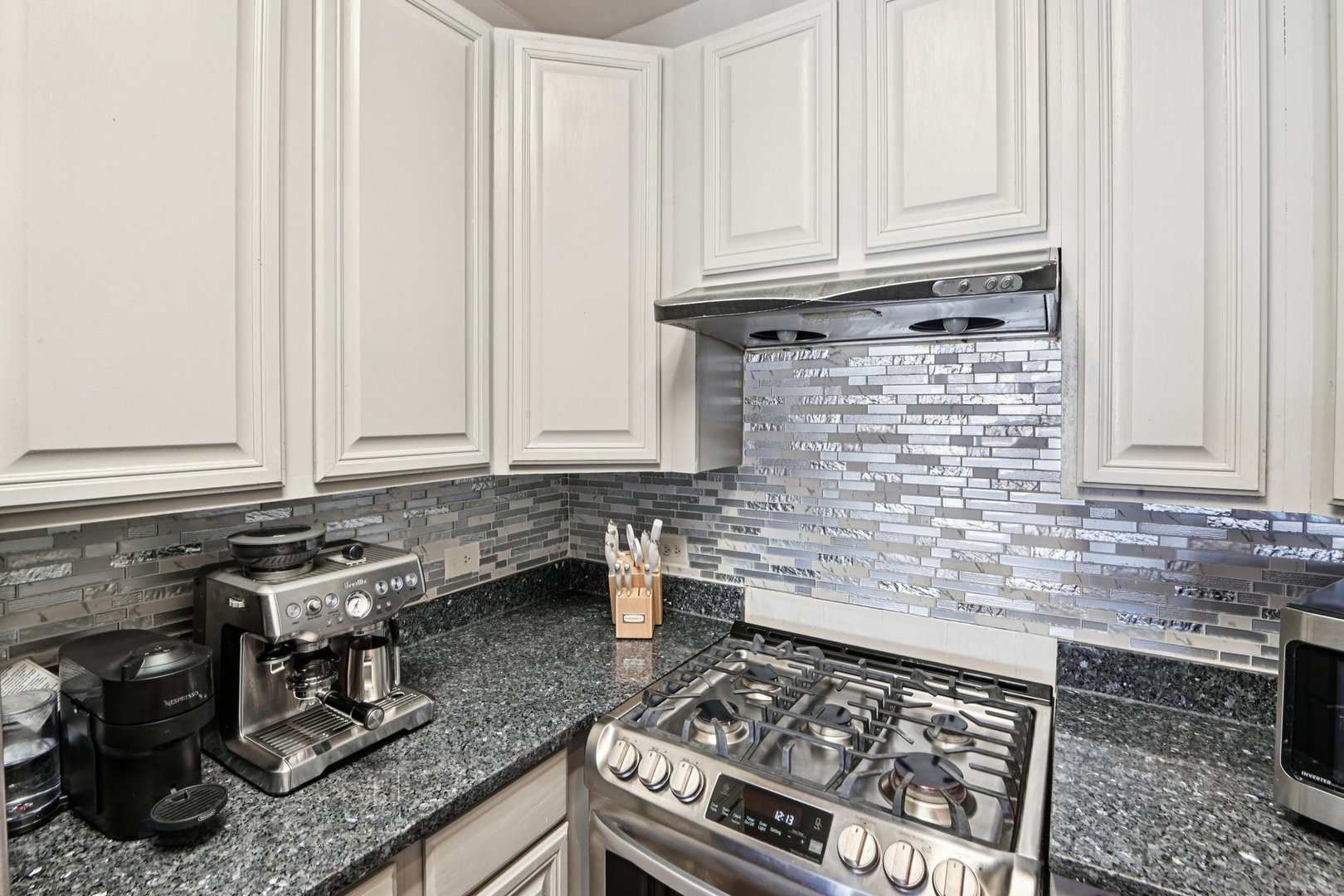 828 West 31st Street, Unit 3N Chicago, IL 60608 - Photo 9 of 29 a kitchen with granite countertop a stove sink and cabinets