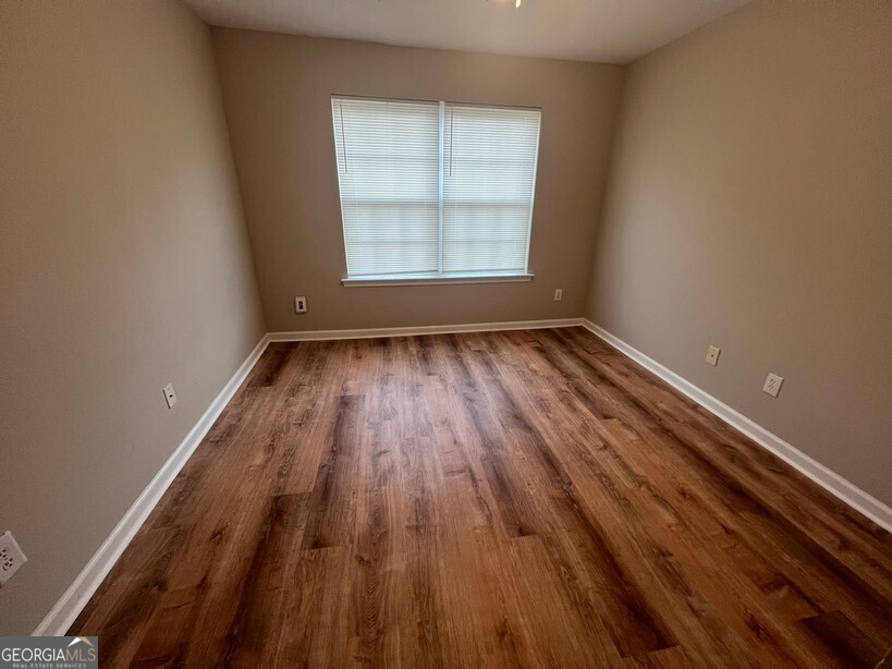 95 Creek Way Covington, GA 30016 - Photo 20 of 25 an empty room with wooden floor and windows