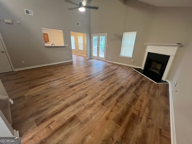 95 Creek Way Covington, GA 30016 - Photo 2 of 25 a view of an empty room with window and wooden floor