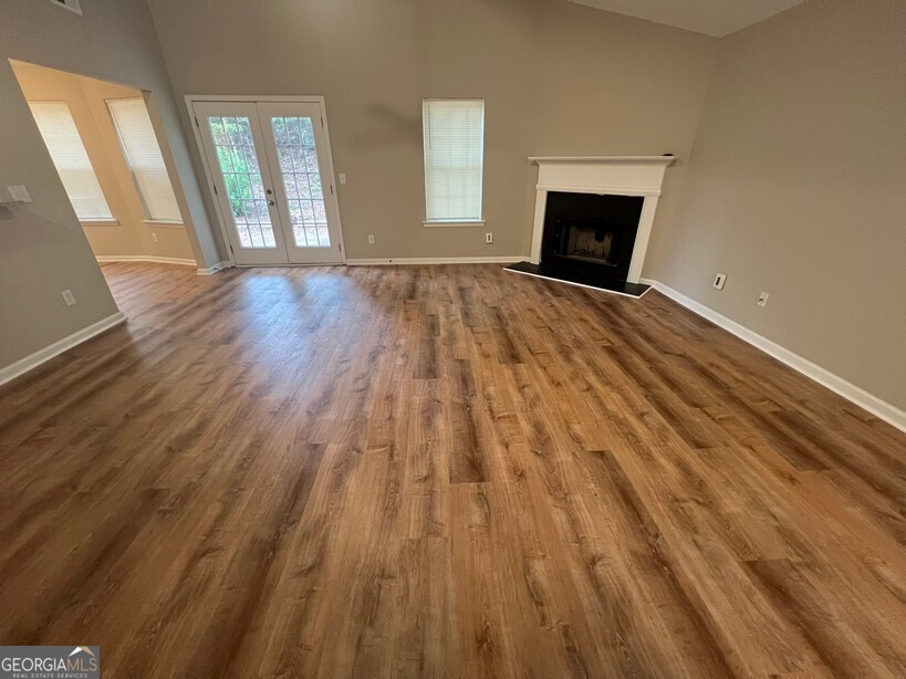 95 Creek Way Covington, GA 30016 - Photo 3 of 25 a view of an empty room with wooden floor and a window