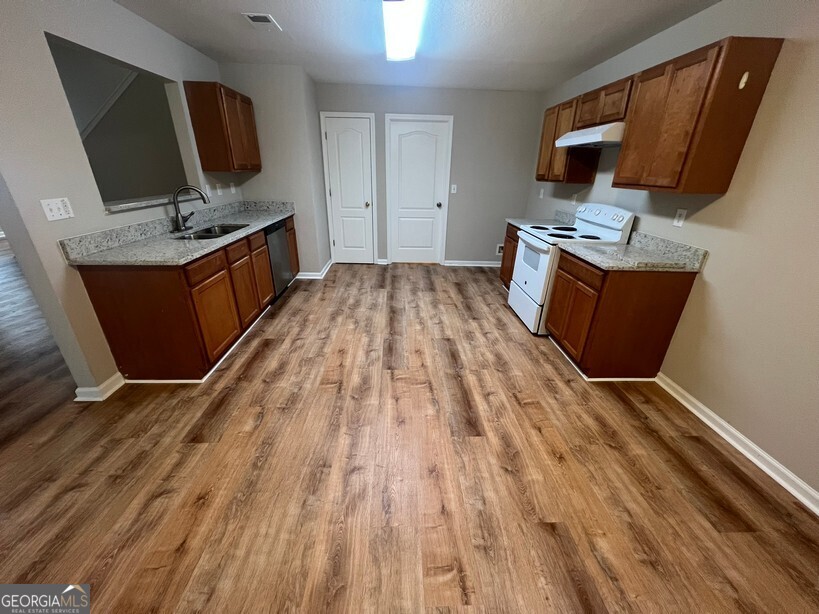 95 Creek Way Covington, GA 30016 - Photo 7 of 25 a kitchen with wooden floor and a sink