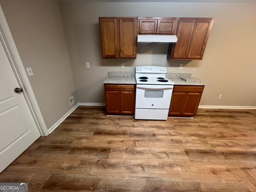 95 Creek Way Covington, GA 30016 - Photo 10 of 25 a kitchen with granite countertop a stove top oven a sink and dishwasher a refrigerator with wooden cabinets