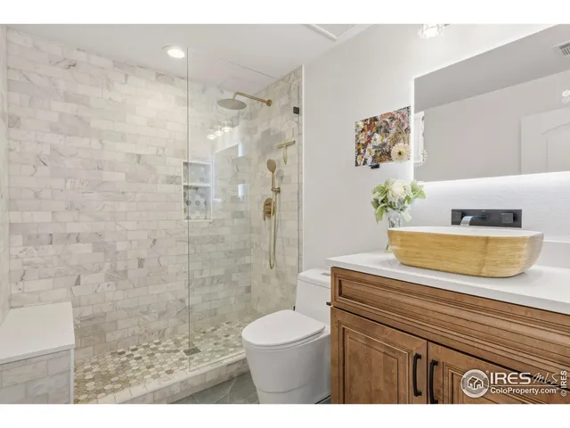a bathroom with a granite countertop sink a toilet and a shower