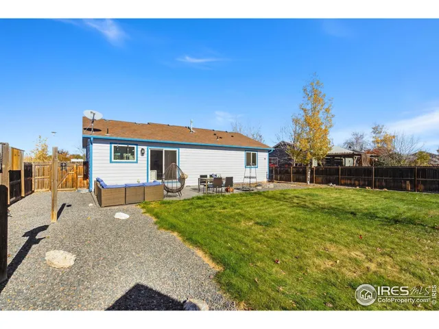 a view of a house with backyard and sitting area
