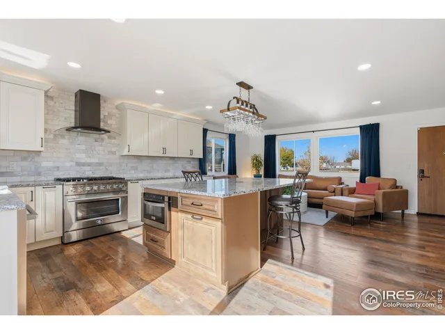a kitchen with kitchen island granite countertop a stove and a sink
