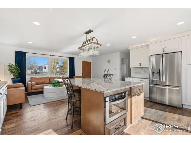 a kitchen with kitchen island a large counter top space appliances and living room view